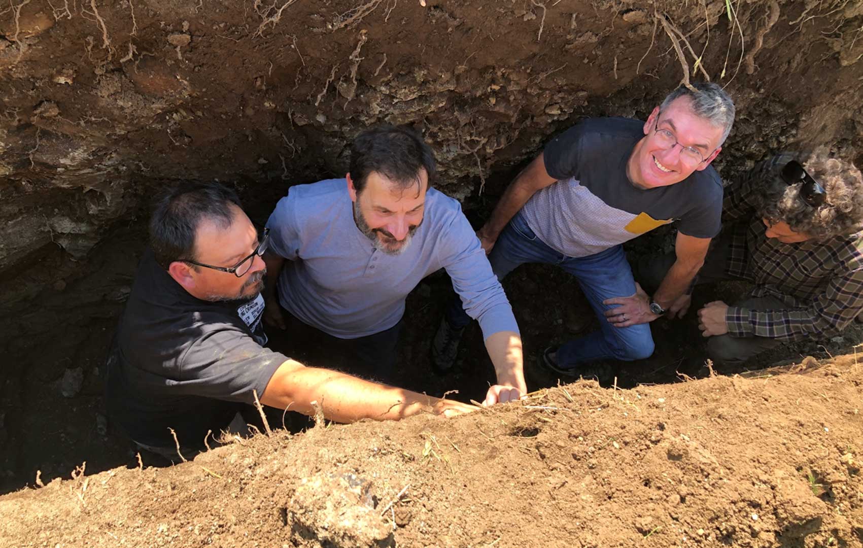Pedro Parra and clients reading a soil pit